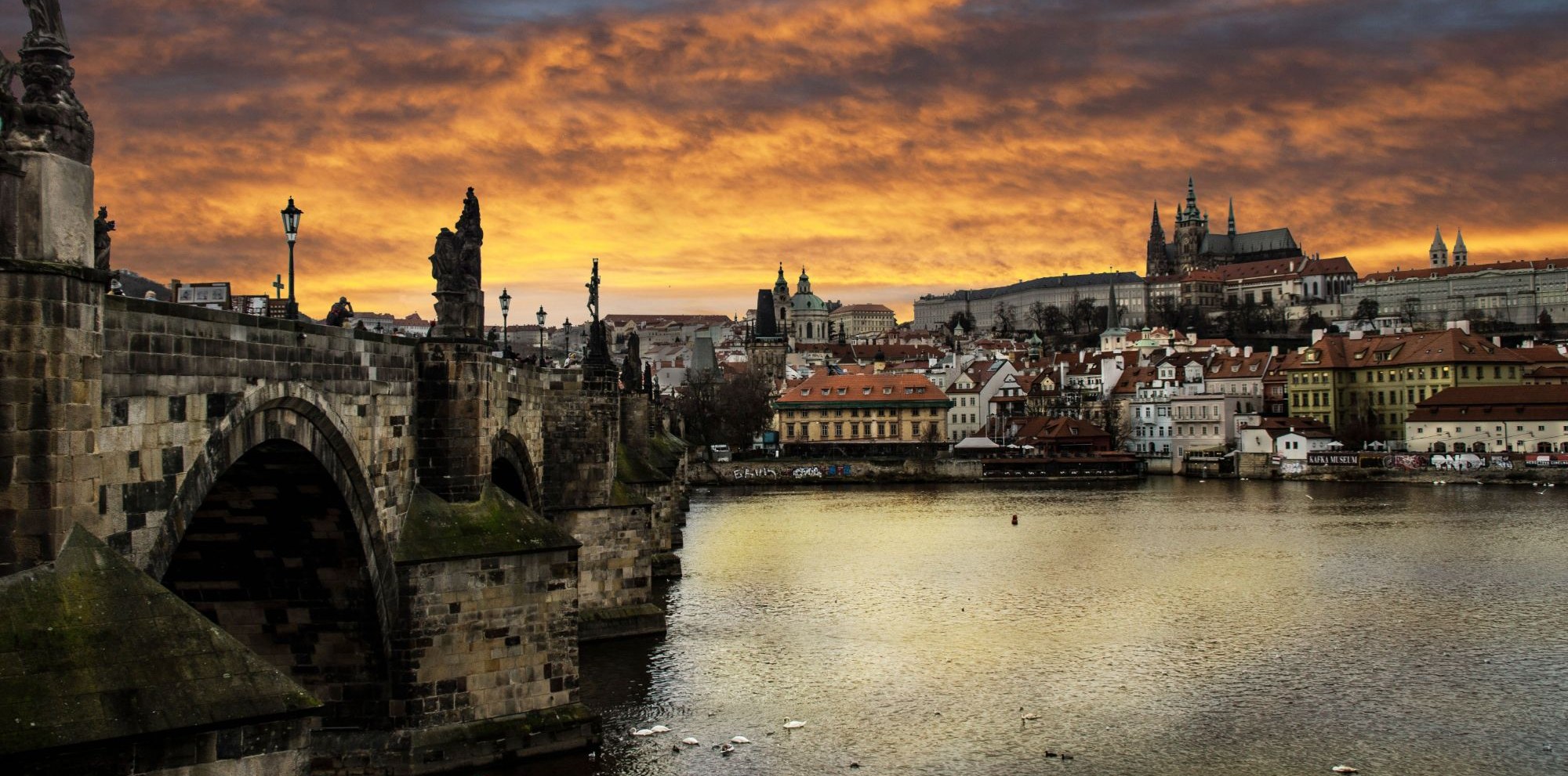 Charles Bridge and Prague Castle under a golden sky